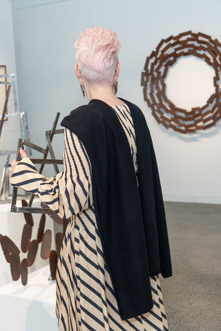 Sophie Vander wears Kasmiri Black Cashmere Wrap in her gallery. Scultpures in the background by Caroline Duffy.