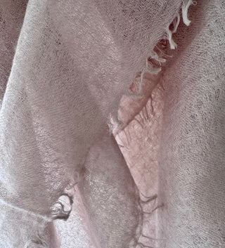Close-up of a textured cashmere scarf in a nude colour.