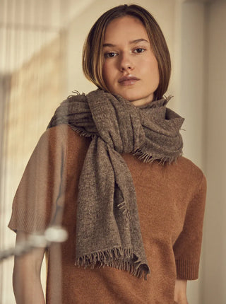 organic undyed cashmere shawl wrapped around the neck of woman wearing a brown top