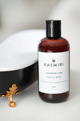 Bottle of Kasmiri Cashmere Care Gentle Wash with a toy bathtub in the background to show that the was is so gentle you can bathe in it. 