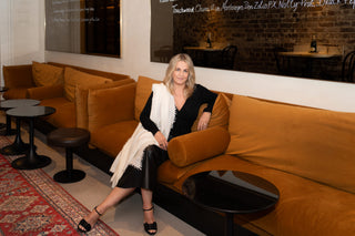 Samantha Theron on a sofa wearing Kasmiri open knit cashmere shawl in white
