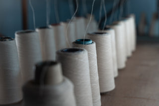 Row of spools of cashmere thread in a kasmiri textile factory setting