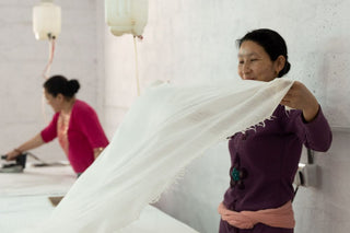 Kasmiri Craftspeople preparing white cashmere shawls for ironing