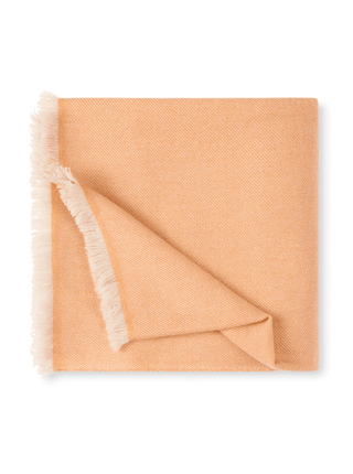 folded cashmere throw in peach fuzz colour with a fringe close up
