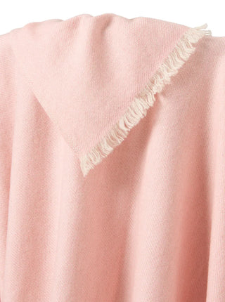 close up of cashmere blanket in a soft pink over a chair to show texture